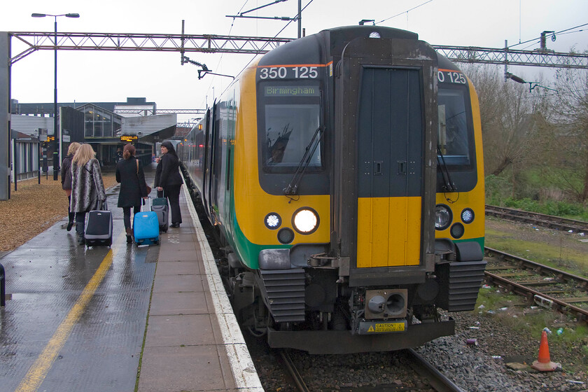 350125, LM 12.49 London Euston-Birmingham New Street (1W13), Northampton station 
 Our train from Northampton to Birmingham International waits to leave having arrived as the 12.49 Euston to New Street London Midland service. As can be seen, it is yet another dismal grey November day that has characterised the last few weeks. 
 Keywords: 350125 12.49 London Euston-Birmingham New Street 1W13 Northampton station