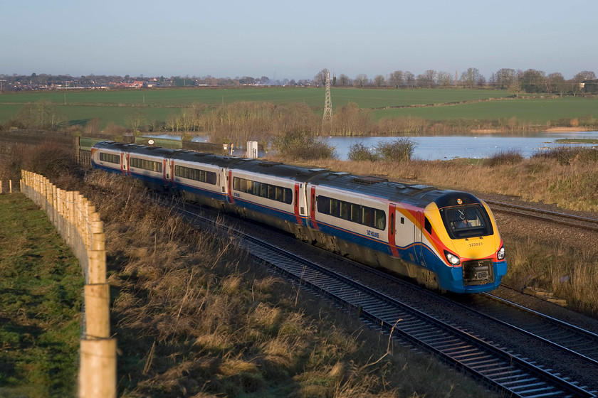 222021, EM 07.04 Lincoln-London St. Pancras (1B21), Irchester Junction SP922673 
 With the arc of the newly installed fencing almost matching the curve of the train an interesting photograph is taken just south of Wellingborough as the MML crosses the Nene Valley. 222012 is working the 07.04 Lincoln to St. Pancras one of the two services per day that link the cities. Plans have been submitted to create a whole new housing area (not just a mere estate) on the land in the background to the left of the transmission pylon so this scene is set to change considerably if they are approved. Also, two years ago the DoT announced plans to electrify the whole of the MML by 2020 so the dreaded masts will also ruin this attractive view of the line. 
 Keywords: 222021 07.04 Lincoln-London St. Pancras 1B21 Irchester Junction SP922673 EMR East Midlands Railway Meridian