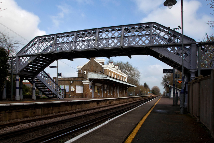 Sandwich Station 
 Looking south east at Sandwich station reveals that the 1847 built structure is in fine condition. Most noticeably, it still has its 'as built' canopy. Also, on the up platform is the original hipped roof waiting shelter even if its side windows have been removed. Quite significantly, the lattice wrought iron footbridge is still in place. Altogether, a smashing station full of character and original features; long may it stay like this! 
 Keywords: Sandwich Station