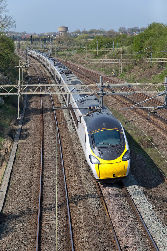 390153, VT 12.35 Manchester Piccadilly-London Euston (1A36, RT), Victoria bridge 
 Under brilliant blue spring skies 390153 heads south past Victoria bridge with the 12.25 Manchester Piccadilly to Euston service. As can be seen, nearly five months after taking over the franchise from Virgin, Avanti West Coast have made virtually no progress re-branding their assets. One wonders if the COVID-19 crisis will slow down the much-anticipated overhaul of the Class 390s that would result in the squadron wide re-building and re-painting of the sets that was announced earlier in the year. 
 Keywords: 390153 12.35 Manchester Piccadilly-London Euston 1A36 Victoria bridge Avanti West Coast Pendolino