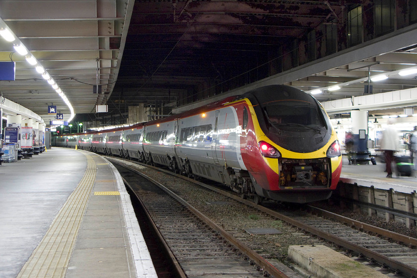 390122, VT 19.30 London Euston-Glasgow Central (1S06), London Euston station 
 Like 390129 'City of Stoke-on-Trent' photographed earlier in the day 390122 'Penny the Pendolino' also has its draw gear cover in the retracted position. This must do nothing for the aerodynamics of these streamlined machines and offers no protection to the equipment in the bay behind the nose cone. 390122 'Penny the Pendolino' waits at Euston to work the final Scottish express of the day, the 19.30 1S06 to Glasgow Central. 
 Keywords: 390122 19.30 London Euston-Glasgow Central 1S06 London Euston station Virgin PendolinoPenny the Pendolino