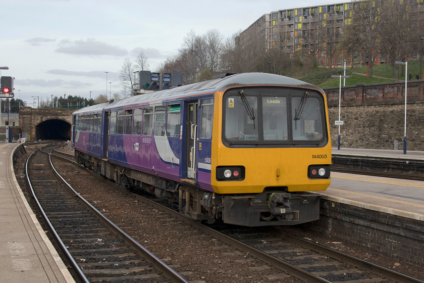 144003, NT 15.15 Sheffield-Leeds (2N21, 4L), Sheffield station 
 144003 leaves Sheffield station with the 15.15 to Leeds. The time that these much unloved units will operate on this route, and all others for that matter, can be counted in months now as they will be withdrawn by the end of the year. Dominating the skyline is part of the massive Park Hill flat complex that is undergoing a huge rebuilding programme. 
 Keywords: 144003 15.15 Sheffield-Leeds 2N21 Sheffield station