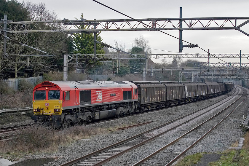 66055, 09.27 Dollands Moor-DIRFT (6M45), site of Castlethorpe station 
 DB's bright red 66055 'Alain Thauvette' leads the daily 09.27 Dollands Moor to Daventry 6M45 train composed of cargo wagons filled with bottled water that has come through the Channel Tunnel from Europe. I suspect that some of the bottles would be frozen today as the previous night had been extremely cold and the day time temperature here at castlethorpe was still only just above freezing. 
 Keywords: 66055 09.27 Dollands Moor-DIRFT 6M45 site of Castlethorpe station