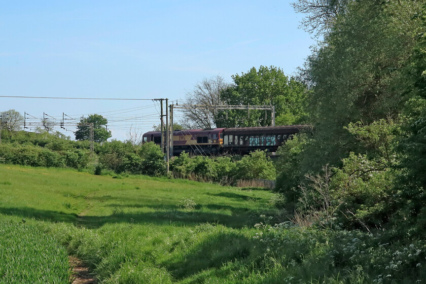 66006, 11.15 Ditton-Dollands Moor (6O26, 6E), between Roade & Ashton 
 As I was walking down to my chosen spot to spend an hour or so watching the trains go by on this glorious spring afternoon I could hear the approach of the 6O26 11.15 Ditton to Dollands Moor service characterised by the noise from its IZA semi-permanently coupled four-wheeled Cargo Wagons. This relatively new flow that heads south through Northamptonshire led by 66006 usually also carries some JLR wagons from Halewood in its consist but not today. 
 Keywords: 66006, 11.15 Ditton-Dollands Moor 6O26 between Roade & Ashton As I was walking down to to my chosen spot on this glorious spring afternoon I could hear the approach of the 6O26 11.15 Ditton to Dollands Moor service characterised by the noise from its IZA semi-permanently coupled four-wheeled Cargo Wagons