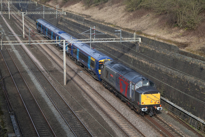 37800 & 375925, 09.45 Chaddesden-Ramsgate EMUD (5Q58), Roade Cutting 
 Rail Operation Group (ROG) won the contract to tow the refurbished class 375s back from Derby to their home at Ramsgate. This meant a regular flow of 37 hauled workings that mostly went via the Midland Main Line, traversed the Bedford to Bletchley route and down the WCML through to London and beyond. However, on this Sunday the trip was diverted and came through Northampton. The ensemble is seen here passing through Roade Cutting with 37800 'Cassiopeia' leading 375925. 
 Keywords: 37800 375925 09.45 Chaddesden Ramsgate EMUD (5Q58), Roade Cutting