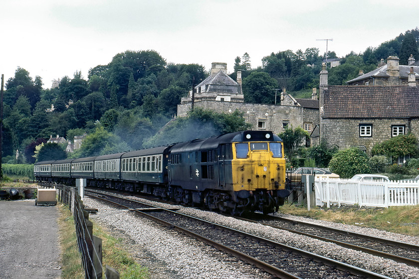 31421, unidentified down working, Limpley Stoke 
 As a local old favourite, 31421 was seen frequently in the West Country on a variety of workings. Here, it is seen passing through the Avon Valley at Limpley Stoke between Bradford-on-Avon and Bath. I do not know the working but it will have been a Portsmouth Harbour to Bristol Temple Meads and/or Cardiff Central service. 31421 was withdrawn in 1997 lingering for ten years at EMR in Kingsbury being cut-up in 2007. Notice the vintage bullhead track still in use and the gold Ford Granda coup parked in the car park. 
 Keywords: 31421 down working Limpley Stoke