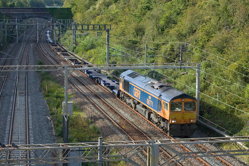 66771, 14.20 Trafford Park-Felixstowe North (4L18, 8E), A508 bridge 
 The lightly loaded 4L18 14.20 Trafford Park to Felixstowe 'liner service passes through Roade seen from the A508 road bridge. It is being led by 66771 'Amanda' which is not one of my most photographed GBRf Class 66s. Notice the two pigeons standing on the portal in the lower left-hand corner totally uninterested in the train about to pass them! 
 Keywords: 66771 14.20 Trafford Park-Felixstowe North 4L18 A508 bridge Amanda GBRf