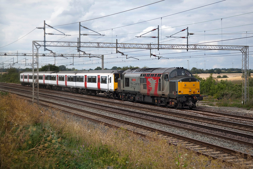 37884 & 317886, 09.00 Kilmarnock Bonnyton-Ilford EMUD (5Q50, 173E), Gordon's Lodge 
 Yet another of Greater Anglia's Class 317s returns from Scotland having received attention at Brodie Engineering's Kilmarnock facility. 37884 'Cepheus' leads 317886 past Gordon's Lodge between Northampton and Milton Keynes running ninety-nine minutes early; something that very nearly caught me out! Unfortunately, I have had to do some heavy Photoshop work to this image as, unbeknown to me, a huge droplet of water or sap or some such substance had deposited itself on the left-hand side of the lens just as the train was approaching. This was probably from the absolute sea of nettles that I was standing in! I saw the same unit heading north just over a month ago hauled by 37800 'Cassiopeia', see...... https://www.ontheupfast.com/p/21936chg/29225554804/x37800-317886-11-59-ilford-emud-killmarnock 
 Keywords: 37884 317886 09.00 Kilmarnock Bonnyton-Ilford EMUD 5Q50 Gordon's Lodge Pheonix Rail ROG Cassiopeia