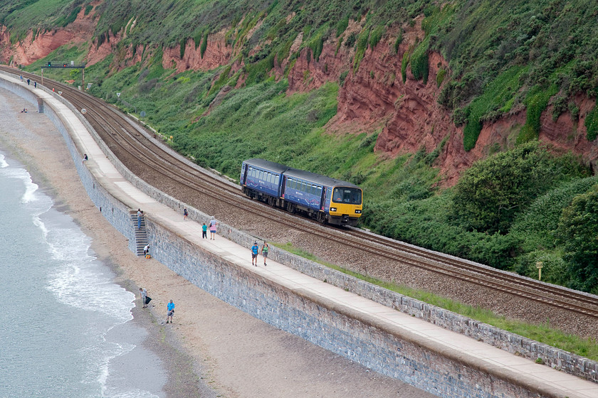 143611, GW 16.00 Paignton-Exeter St. Davids (2E44, 1L), Langstone Rock 
 Langstone Rock offers a commanding view not only of the railway but the coast. Andy and I spent an hour or so sitting on top of it taking pictures. Looking a little dwarfed by its surroundings, 143611 forms the 16.00 Paignton to Exeter St. David's as it approaches its stop at Dawlish Warren. 
 Keywords: 143611 2E44 Langstone Rock