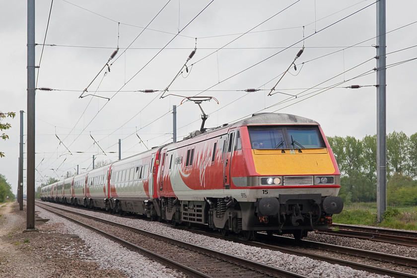 91115, GR 11.03 London Kings Cross-Leeds (1D11, 5L), White House Crossing TL227777 
 91115 'Blaydon Races' races north past White House Crossing north of Huntingdon with the 11.03 King's Cross to Leeds. White House Crossing is a foot crossing that Network Rail want to close situated on the three-track section of the ECML. This closure is part of their almost obsessive programme of removing all crossings across the network. 
 Keywords: 91115 1D11 White House Crossing TL227777