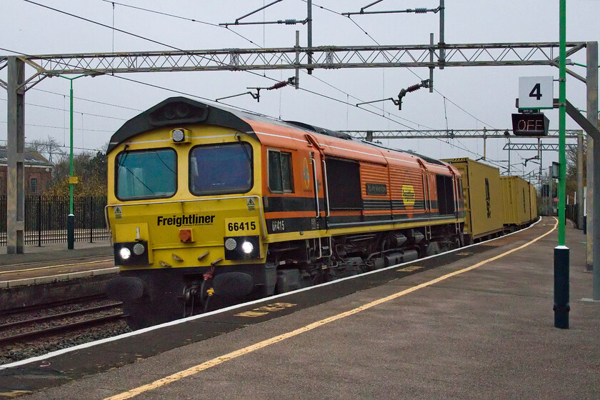 66415, 03.14 Garston-Felixstowe North (4L97, 24E), Wolverton station 
 66415 'You Are Never Alone' sweeps through Wolverton station on what is, yet again, another miserable and grey November day. The Freightliner locomotive is leading the 4L97 03.14 Garston to Felixstowe North service which appears to be well loaded. However, after the first few wagons had passed with boxes loaded the rest of the train was completely empty. 
 Keywords: 66415 03.14 Garston-Felixstowe North 4L97 Wolverton station You Are Never Alone Freightliner