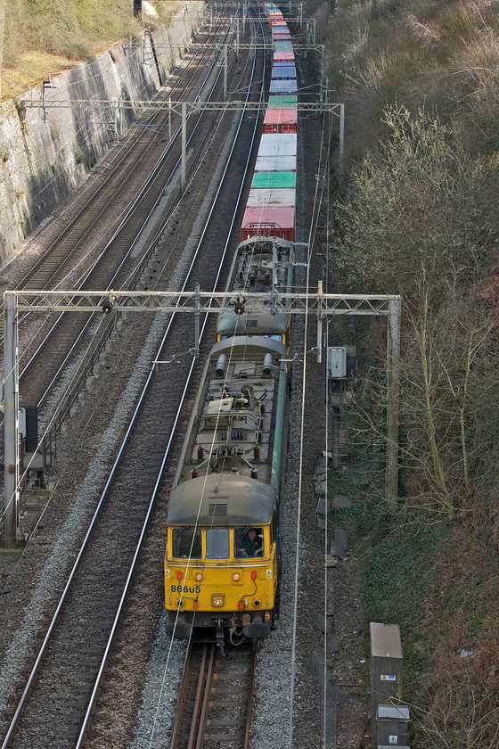 86605 & 86637, 11.13 Felixstowe-Trafford Park (4M27, 21E), Roade cutting 
 Fast becoming the norm is the use of the Weedon line, thus avoiding Northampton, for freight due to huge gaps in the timetable as a result of the Covid-19 travel restrictions. A regular freight that is using this route almost daily is the 4M27 11.13 Felixstowe to Trafford Park Freightliner that is pretty much always handled by a pair of Class 86s. In this view of Roade cutting, 86605 and 86637 get a move on with the well-loaded train that arrived twenty-one minutes early at its destination later in the day. 
 Keywords: 86605 86637 11.13 Felixstowe-Trafford Park 4M27 Roade cutting Cans Freightliner