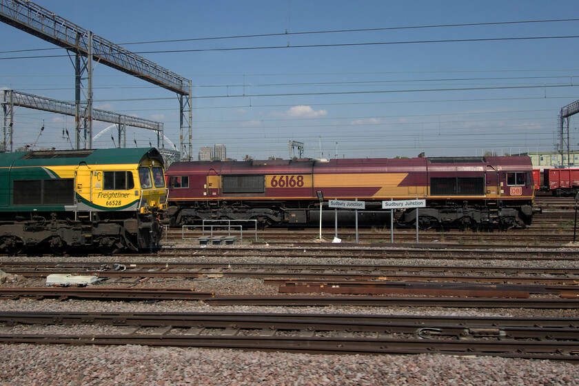 66528, 12.24 Wembley Reception-Merehead (6C77, 222L) & 66168, 11.26 London Victoria-Wembley reception (0Z66, 30L), Wembley Yard 
 In a study of different liveries, 66528 stands next to 66169 at Wembley Yard's Sudbury Junction. The EWS liveried version spent most of the day stabled at this spot having hauled the Pullman stock into Victoria earlier in the morning that was to work the Belmond British Pullman to Gillingham. Later in the day, it would return to remove the empty stock to Stewart's Lane. Meanwhile, the Freightliner locomotive would work the 6C77 12.24 to Merehead service that should already have left when we passed it, it did soon after this photograph was taken arriving at its destination an hour adrift. 
 Keywords: 66528 12.24 Wembley Reception-Merehead 6C77 66168 11.26 London Victoria-Wembley reception 0Z66 Wembley Yard EWS Freightliner