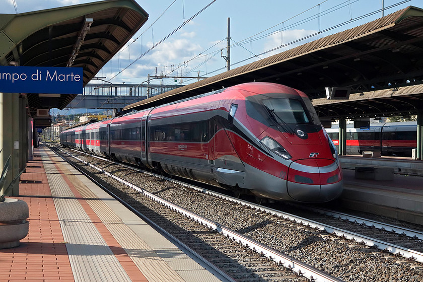 1000.005, unidentified working, Florence CM station 
 An unidentified working heads south through Florence CM station in the evening sun. It is being worked by one of Trenitalia's new Frecciarossa 1000 high speed trains, 1000.005. These unit, launched in 2015, were designed by Ansaldo Breda, in partnership with Bombardier who built the trains. There was also input from the Italian design house Bertone. 
 Keywords: 1000.005 unidentified working Florence CM station