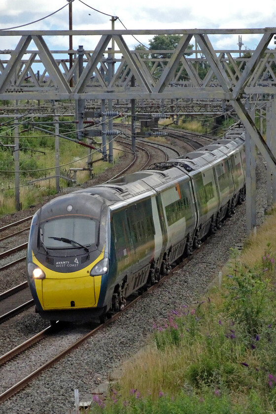 390112, VT 13.32 London Euston-Manchester Piccadilly (1H68, 11L), site of Roade station 
 390112 sweeps around the cambered curve on the approach to Roade working the 13.32 Euston to Manchester Sunday service. Until this point, the track from London has been relatively free from curves but here until past Rugby there are some sharp curves that are deeply cambered and where maximum use is made of the pendolino's tilting capabilities. The speed limit is also a little lower than further south. 
 Keywords: 390112 13.32 London Euston-Manchester Piccadilly 1H68 site of Roade station AWC Avanti Pendolino.jpg