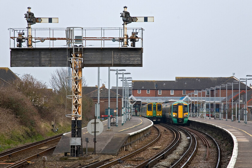 313210, SN 17.11 Littlehampton-Bognor Regis & 377419, SN 17.15 Littlehampton-London Victoria, Littlehampton station 
 Despite being only five miles apart from each other as the crow flies Littlehampton and Bognor Regis enjoy a direct railway service that takes a more circuitous route inland via Ford and Barnham with a short dash along the Coastway route, a distance of nearly nine miles. 313210 is about to leave Littlehampton with the 17.11 evening service to Bognor whilst 377419 will soon depart with 17.15 train to London Victoria. Andy can just be seen on the platform about to board the earlier train that he would take to Ford where I was to pick him up in the car as this was virgin track for him! 
 Keywords: 313210 17.11 Littlehampton-Bognor Regis 377419 17.15 Littlehampton-London Victoria, Littlehampton station Southern