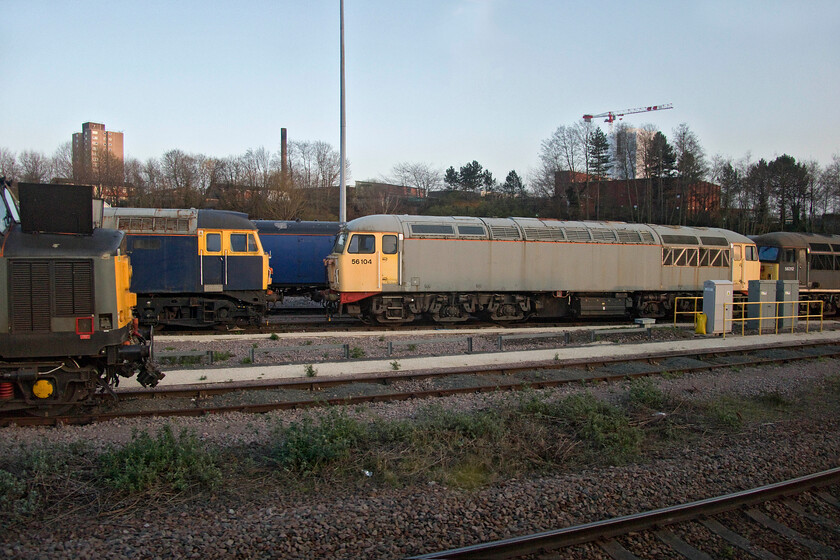 37800, 47843, 56104 & 56312, stabled, UKRL depot 
 An eclectic mix of BR era diesels stands at UKRL's Leicester depot which is the site of the former diesel depot that fell into somewhat sporadic use from 1987 becoming very overgrown and run down. It has now been reborn and looks functional and organised as UKRL's centre of activity. In this scene taken from our passing train 37800 is seen to the extreme left with Railfreight grey liveried 56104 taking centre stage and 47843 squeezed in between the two. To the extreme right is 56312 which still wears its Devon & Cornwall Railway livery. I last photographed this particular Grid back in May 2014 at one of the NVR's popular diesel galas but since then it has lost its nameplates, see.... https://www.ontheupfast.com/p/21936chg/30013191661/x56312-15-30-peterborough-nv-wansford 
 Keywords: 37800 47843 56104 56312 UKRL depot