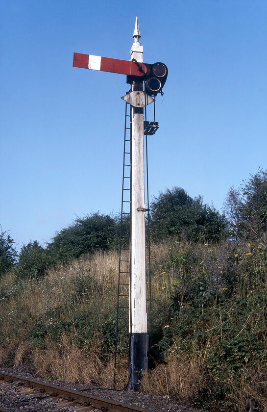 Midland upper quadrant home signal, Ketton SK981038 
 Back in 1981, when this photograph was taken, this signal and post was a remarkable survivor however the fact that it is still extant today in 2023 is even more so! The Ketton down section signal is a wooden lower quadrant arm on a wooden post topped off with a fine finial. It was probably installed when the box was opened by the Midland in 1900. Its survival today is even more extraordinary as all the other semaphores controlled by Ketton have been replaced but colour lights leaving this antique piece of infrastructure the only piece of mechanics in operation! 
 Keywords: Midland upper quadrant home signal Ketton SK981038