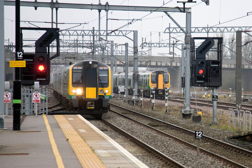 350250, LM 09.24 London Euston-Milton Keynes Central (2K29) & 350119, LM 07.55 Crewe-London Euston (1U22), Milton Keynes Central station 
 A passing of London Midland trains at Milton Keynes station. To the left, 350250 arrives with the 09.24 from London Euston that will terminate. The the right, 350119 leaves after its stop at the station working the 'fast' 1U22 07.55 Crewe to London Euston. 
 Keywords: 350250 09.24 London Euston-Milton Keynes Central 2K29 350119 07.55 Crewe-London Euston 1U22 Milton Keynes Central station