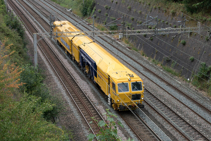 DR75012, 11.30 Hanslope Junction-Northampton Castle Yard (6Q60, 1L), Roade cutting 
 SB Rail's Class ZWA-Unimat 09-4x4/4S Dynamic Tamper passes through Roade cutting as the 6Q60 11.30 Hanslope Junction to Northampton Castle Yard move. This followed overnight engineering works somewhere south of Hanslope. 
 Keywords: DR75012 11.30 Hanslope Junction-Northampton Castle Yard 6Q60 Roade cutting