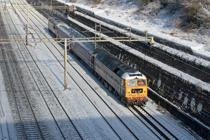 47739 & 56081, 07.52 Leicester LIP-Wolverton Centre Sidings (5Z20, 65L), Roade cutting 
 Running over an hour late, 47739 leads two barrier coaches and 56081 on the back through a cold and snowy Roade cutting. The 5Z20 07.52 Leicester to Wolverton left its base behind time and never recovered losing even more minutes during its journey. It was undertaking this trip in connection with the dragging of a Class 720 (720554) later in the day to Derby. Unfortunately, this was routed via the Marston Vale line and the Midland route so would not return through Roade. On a normal non-COVID lockdown day I may well have gone to see it but, at the moment, this could not really be justified as essential travel! 
 Keywords: 47739 56081 07.52 Leicester LIP-Wolverton Centre Sidings 5Z20 Roade cutting GBRf