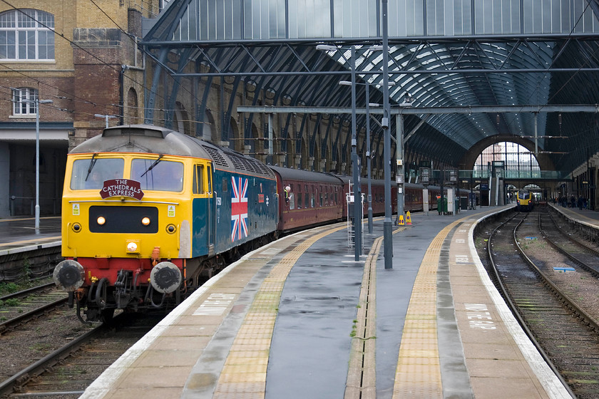 47580, outward leg of The Cathedrals Express, 09.11 London King's Cross-Shildon (1Z24) & 180109, 10.42 London King's Cross-Hull (1H02), London King's Cross station 
 47580 'County of Essex' gets the 1Z24 Cathedrals Express away from King's Cross at exactly the right time heading for Shildon on County Durham. The charter was also named The Great Goodbye taking passengers to see, for the last time, all six surviving A4 streamlined Pacifics together in one place celebrating the seventy-fifth anniversary of Mallard's speed record in 1938. To the right and totally dwarfed by the trainshed towering above it is 180109 that will work the 10.42 to Hull. 
 Keywords: 47580 The Cathedrals Express 09.11 London King's Cross-Shildon 1Z24 180109 10.42 London King's Cross-Hull 1H02 London King's Cross station County of Essex