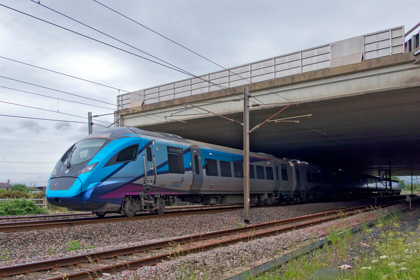 397001, TP 12.07 Glasgow Central-Liverpool Lime Street (1M87 1L), Mossband M6 bridge NY347654 
 An unusual angle but one that I actually like showing the vast concrete structure named Mossband bridge that carries the M6 across the WCML just south of Gretna. The bridge was opened in December 2008 along with the associated section of motorway linking the M6 with the M74 by Lord (Andrew) Adonis that had long been a congested section of road that the English Highways Agency and the Scottish Executive had spent many years wrangling over as to how to solve. 397001 passes under the bridge working the 12.07 Glasgow to Liverpool TPE service. 
 Keywords: 397001 12.07 Glasgow Central-Liverpool Lime Street 1M87 Mossband M6 bridge NY347654