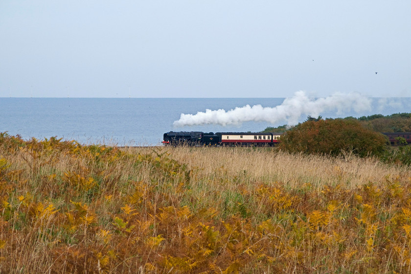 92203, 12.00 Sheringham-Holt, The North Norfolkman dining train, Weybourne Wood TG127424 
 Throughout the season on Sundays, the North Norfolk Railway operates The North Norfolkman dining train. My wife, son and I have travelled on this special dining train and found it to be well patronised offering a great service. The railway simply attaches two dining coaches with a full kitchen to its 12.00 and 13.30 Sheringham to Holt and return service trains to avoid the expense of operating a 'special' working. 92203 'Black Prince' leads the 12.00 service along the coast 'twixt sea and pine' as their strapline proclaims near Weybourne Wood. 
 Keywords: 92203 12.00 Sheringham-Holt, The North Norfolkman dining train, Weybourne Wood TG127424 9F Black Prince