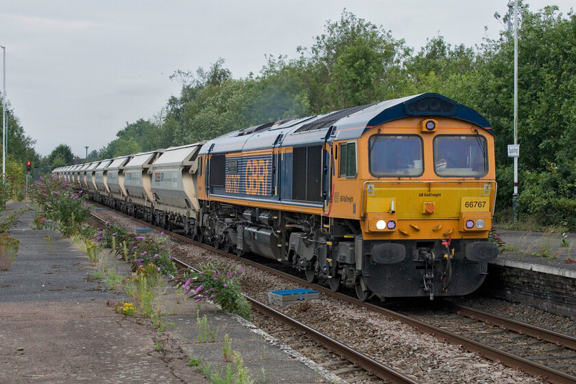 66767, 08.15 Middleton Towers-Barnby Dun (6E85, 30L), Spalding station 
 One of the regular sand flows from Middleton Towers near King's Lyn passes through Spalding station led by 66567 'King's Cross PSB 1971-2021'. The 6E85 to Barnby Dun near Doncaster takes the sand to the Ardagh Glass factory which is actually located in Kirk Sandall rather than its timetabled destination which is some distance to the north east. 
 Keywords: 66767 08.15 Middleton Towers-Barnby Dun 6E85 Spalding station King's Cross PSB 1971-2021