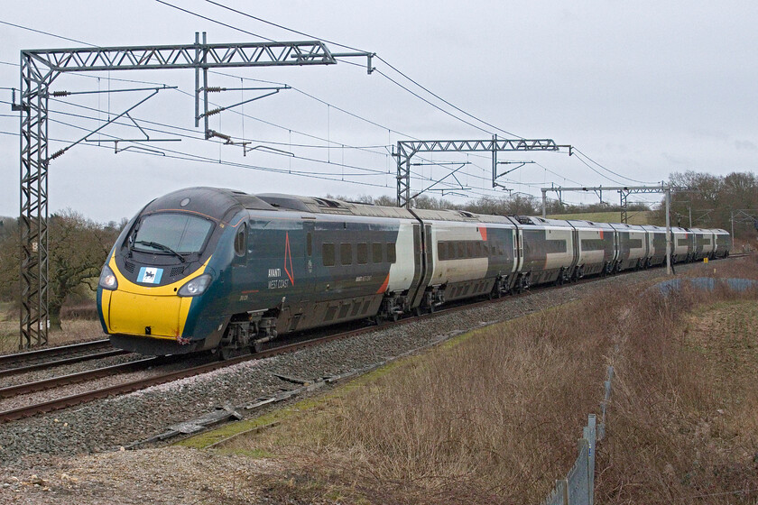 390039, VT 11.52 London Euston-Birmingham New Street (9G19, 1L), Milton Crossing 
 390039 'City of Coventry' emerges from the depths of Roade cutting past Milton crossing working the 9G16 11.52 Euston to Birmingham New Street service. This is one of my favoured spots close to home with good photographs possible in both directions, but, unfortunately, it is on the fast line, so most of the interesting trains do not pass this way going via Northampton on the slow lines! 
 Keywords: 390039 11.52 London Euston-Birmingham New Street 9G19 Milton Crossing City of Coventry