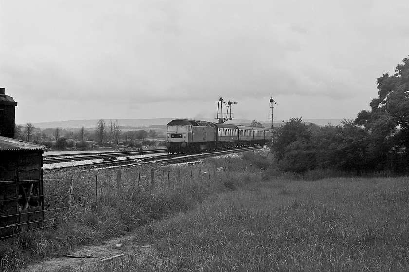 47052, unidentified up working, Cogload Junction 
 47052 takes the up fast line past Cogload Junction. The train is on the inner up line and will thus go via Westbury heading for Paddington. I have not been able to identify this working but, that there is a buffet car marshalled into the train as the first coach would indicate that it probably originated from Paignton. 
 Keywords: 47052 unidentified up working Cogload Junction