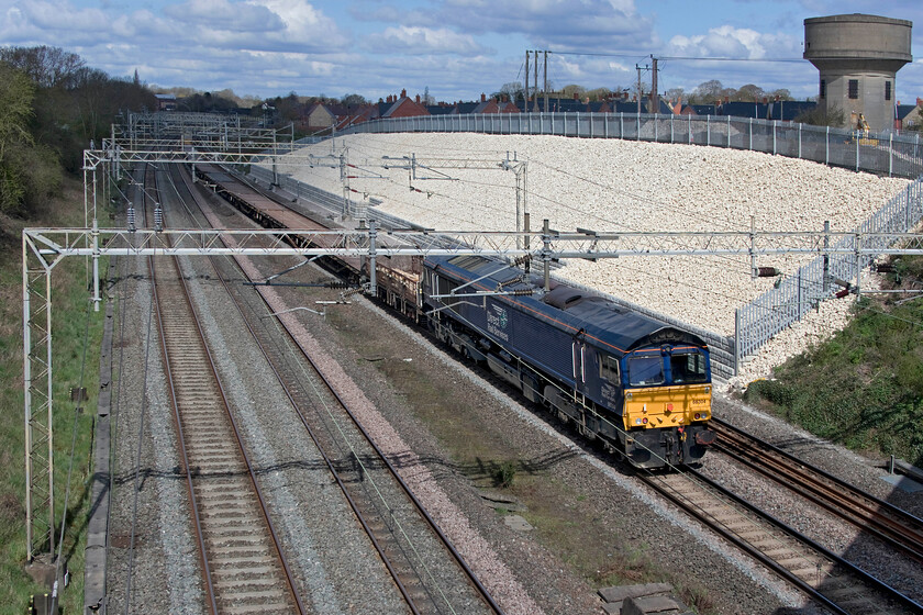 66304, 10.18 Kings Langley-Bescot (6G52, 3E), Ashton Road bridge 
 A bit of 'grab' shot sees me crossing Ashton Road bridge with my step ladder and getting a poorly composed photograph of 66304 dead-in-tow at the rear of the 10.18 6G52 Kings Langley to Bescot engineering train. Notice the recently completed bank stabilisation work dominating the scene somewhat. 
 Keywords: 66304 10.18 Kings Langley-Bescot 6G52 Ashton Road bridge DRS