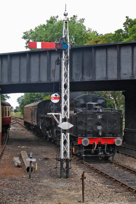 76084, 12.00 Holt-Sheringham, Sheringham station 
 Running tender first into Sheringham station Class 4 2-6-0 76084 arrives with the 12.00 service from Holt. It is passing a fine latticed signal post that supports the up starter and a shunting disc signal. Notice the white diamond attached to the shunting signal and the post. As part of Rule 55 this indicates to the train crew that they do not need to contact the signaller as no telephone is provided for that purpose. Instead, the signaller will know of the train's presence because track circuits are in operation. 
 Keywords: 76084 12.00 Holt-Sheringham Sheringham station NNR North Norfolk Railway