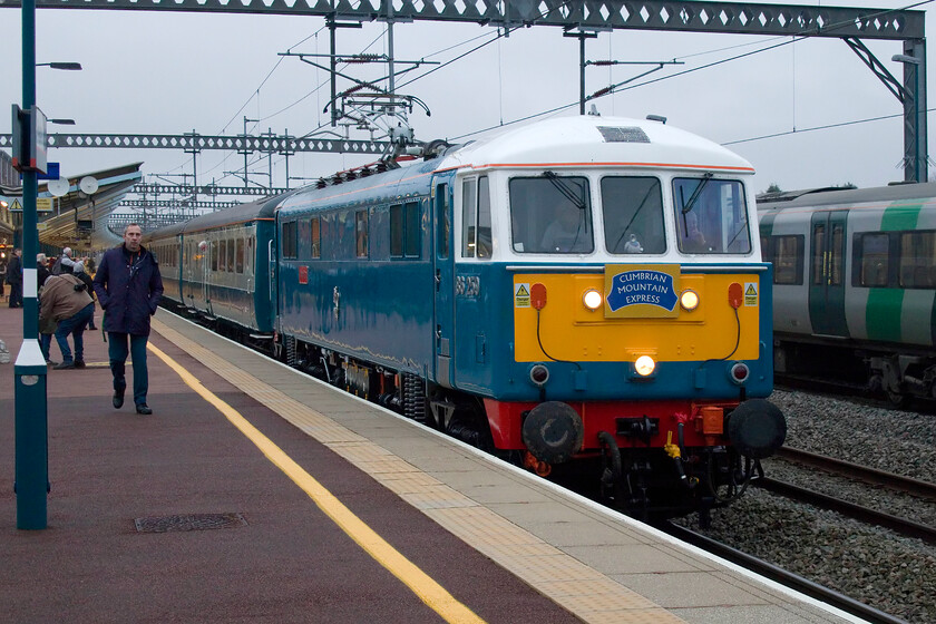 86259, outward leg of The Cumbrian Mountain Express, 06.39 London Euston-Carlisle (1Z86, 9L), Rugby station 
 86259 'Les Ross/Peter Pan' arrives at Rugby leading the first Cumbrian Mountain Express of the year. The always smart-looking AL6 that lives at Rugby when not in use, is wearing a smart new headboard produced for the 2025 season. The 06.39 Euston to Carlisle train, with steam taking over from Carnforth, was carrying its owner in the cab. Les Ross can just be seen standing wearing a white tee-shirt emblazoned with an image of his locomotive. 
 Keywords: 86259 The Cumbrian Mountain Express 06.39 London Euston-Carlisle 1Z86 Rugby station Les Ross Peter Pan