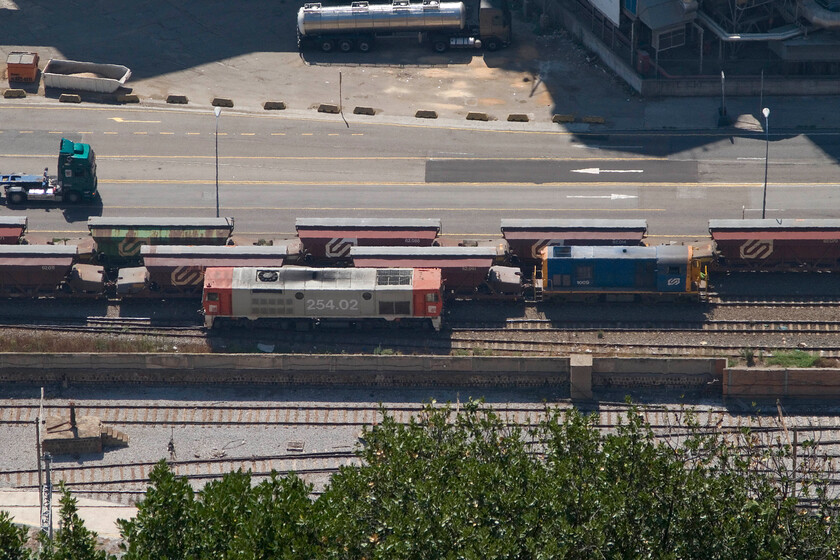 254 02, stabled & 1009, shunting wagons, Barcelona Harbour, from Montjuc Castle 
 Another view from the parapets of Barcelona's Montjuc Castle sees what I believe to be an empty potash train being marshalled ready to return to Sria high up in the mountains to the west of Barcelona. 254 02 is also seen that will take the train from the harbour empty on the metre gauge track. This is one of just three locomotives dedicated to this work which were constructed in 1990 by Meinfesa, a subsidiary of Stadler. Notice the gauge differences between the tracks in the foreground and those that the trains are on. 
 Keywords: 254 02 1009, shunting wagons Barcelona Harbour from Montjuc Castle