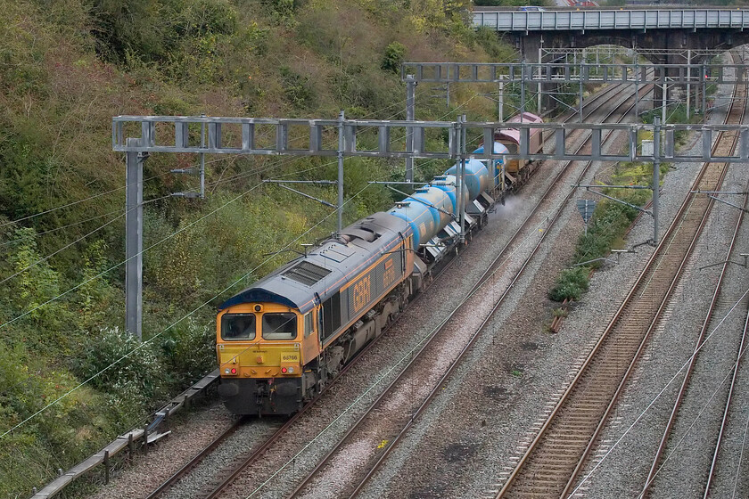 66766 & 66734, 10.30 King's Norton-King's Norton (3J01, 4E), Hyde Road bridge 
 Passing through Roade 66766 'Gail Richardson' brings up the rear of the conveniently timed 3J01 King's Norton return RHTT service with 66734 'Platinum Jubilee' leading. This treatment train makes a double return trip along the Marston Vale line from Bletchley to Bedford perhaps due to its very limited use at the moment with passenger trains having still yet to be reinstated. I may get one more chance to photograph this train next Saturday but beyond that, the lighting will be marginal as after then, the clocks will have gone back lunging us into 'winter time'. 
 Keywords: 66766 66734 10.30 King's Norton-King's Norton 3J01 Hyde Road bridge Platinum Jubilee Gail Richardson