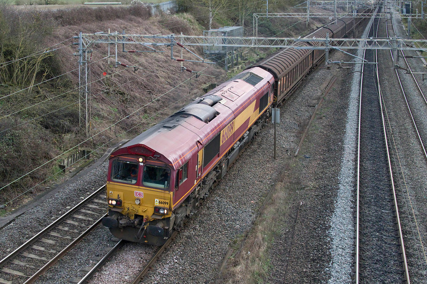 66099, 09.06 Dollands Moor-DIRFT (6C24, 4L), Victoria bridge 
 With the old EWS livery now looking a little faded 66099 leads the 09.06 Dollands Moor to Daventry freight terminal pass Victoria bridge just south of Roade. This daily working brings imported bottled water into the UK via the Channel Tunnel. In recent weeks, the Hbbills 311 sliding door wagons have been supplemented by some containers marshalled at the back of the service and out of sight in this image. 
 Keywords: 66099 09.06 Dollands Moor-DIRFT 6C24 Victoria bridge EWS DB