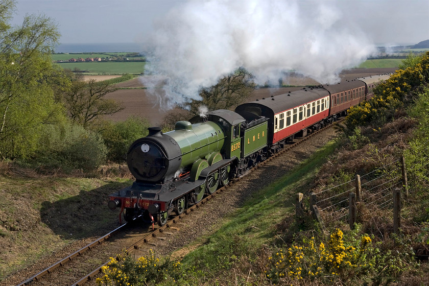 8572, 09.45 Sheringham-Holt, Kelling bank 
 With the light transformed from yesterday morning at the same spot today's photograph really comes alive! With the North Sea in the background, B12 8572 charges up Kelling bank leading the North Norfolk Railway's first service of the day, the 09.45 Sheringham to Holt. I have visited this spot many, many times but never tire of it. Sitting on the grass and taking in the grand vista waiting for a train is just perfect when the weather is like this. 
 Keywords: 8572 09.45 Sheringham-Holt Kelling bank Poppy Line NNR North Norfolk Railway LNER B12 4-6-0