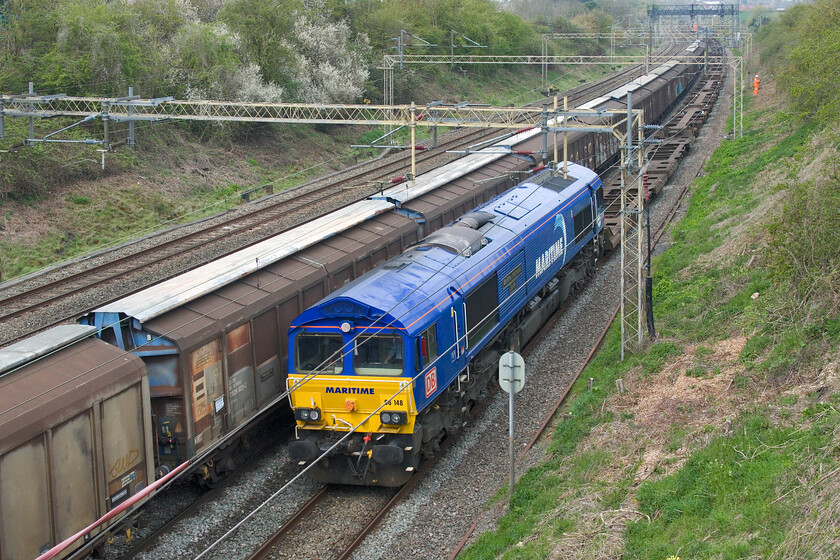 66148, 05.27 Wakefield Europort-Didcot TC (4O43, 31L) & 06.34 Dollands Moor-DIRFT (6M45, 4E), Victoria bridge 
 The 6M45 06.34 Dollands Moor to DIRFT water train is in the final few miles of its journey as it passes Victoria bridge just south of Roade whilst the diverted 4043 05.27 Wakefield Europort to Didcot continues its rather convoluted diverted journey south led, as it was yesterday, by 66148 66148 Maritime Intermodal Seven. Unlike yesterdays run that went straight through to Southampton today it was to continue along the GWML from Reading to Didcot. After a short break during which I presume the locomotive ran round, it retraced its steps back to Reading and then south to Southhampton running now as 4O43 which is the correct reporting number for this train. 
 Keywords: 66148 05.27 Wakefield Europort-Didcot TC 4O43 06.34 Dollands Moor-DIRFT 6M45 Victoria bridge Maritime Intermodal Seven