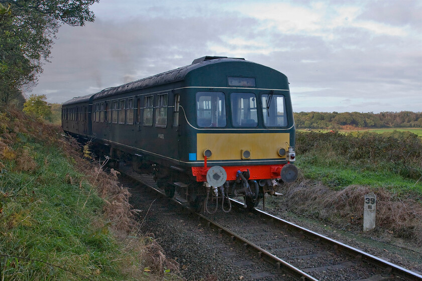 M56352 & M51192, 09.45 Sheringham-Holt, Weybourne woods TG115418 
 The 09.45 Sheringham to Holt service passes through Weybourne woods on the climb towards Kelling Heath worked by M56352 and M51192. It has just passed the thirty-nine and three-quarters milepost, the distance to Midland and Great Northern Joint Railway's junction with the Great Eastern at King's Lyn. 
 Keywords: M56352 M51192 09.45 Sheringham-Holt Weybourne woods TG115418 Class 101 DMU