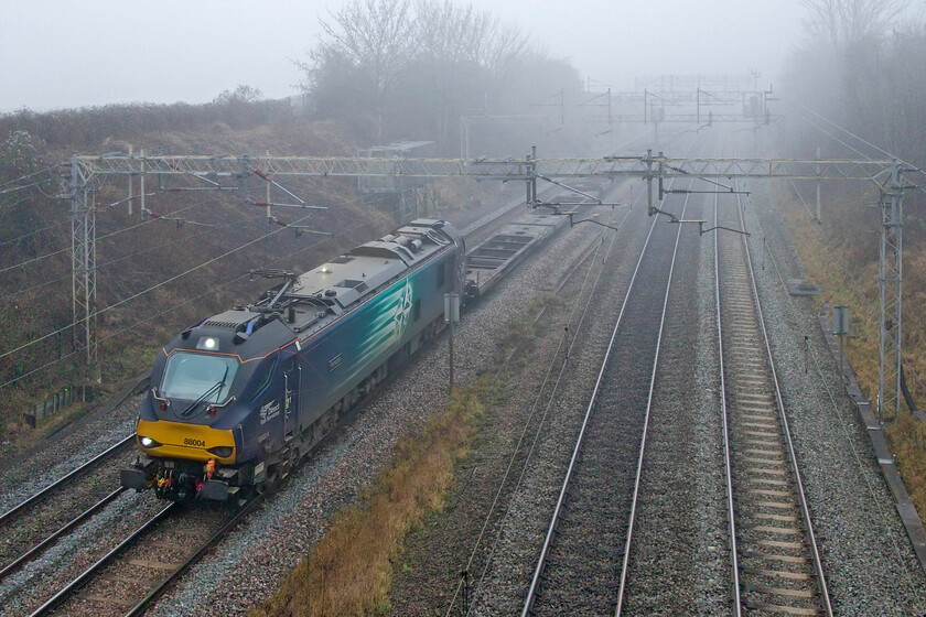 88004, 09.59 Tilbury-Coatbridge (4S10, 65E), Victoria bridge 
 A new regular freight flow running on a Sunday is the 4S10 09.59 Tilbury to Coatbridge that passes north through Northamptonshire is a popular one bringing a little more diversity to the line. It usually produces a Class 88, a class not seen that frequently this far south. At a very foggy Victoria bridge between Milton Keynes and Northampton 88004 'Pandora' leads the train with the first half being devoid of any boxes, the rear of the train was more healthily loaded. 
 Keywords: 88004 09.59 Tilbury-Coatbridge 4S10 Victoria bridge DRS Direct Rail Services Pandora