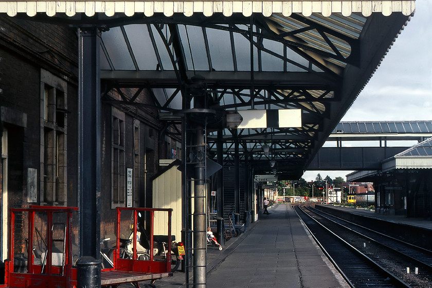 Platform 2, Aylesbury station 
 The view looking roughly south along Aylsebury's platform two is characterised by its absence of travellers. I am sure that on a weekday morning this would be a little different with many commuters packed on the narrow platform heading for London by one of two routes, either directly to Marylebone or via the Metropolitan Line that they would pick up at Amersham. Notice the platform placed down starter signal that looks as if it could make contact with the head of a tall passenger innocently standing underneath it when it was pulled off! 
 Keywords: Platform 2 Aylesbury station