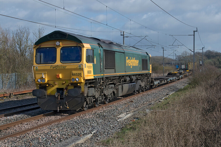 66520, 09.12 Felixstowe North-Trafford Park (4M63, RT), Bugbrooke footbridge 
 The 4M63 09.12 Felixstowe to Trafford Park Freightliner is seen 'off-route' being led by 66520. The train is seen on the Weedon 'fast' line away from its more usual route via the Northampton loop. Normally, freight is kept well away from this route but things on the railways are far from normal at the moment; along with the rest of everyday life! The Crick tunnel was undergoing a week-long closure for drainage works taking advantage of the much reduced national timetable thus enabling freight on this route. 
 Keywords: 66520 09.12 Felixstowe North-Trafford Park 4M63 Bugbrooke footbridge