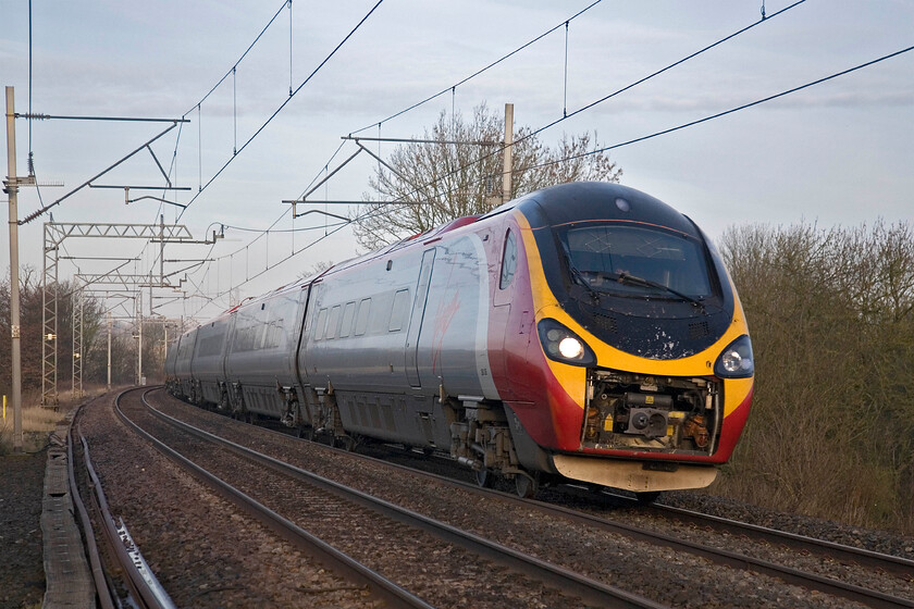 390126, VT 06.35 Manchester Piccadilly-London Euston, Bugbrooke SPO676565 
 Doing nothing for its aerodynamic properties 390126 'City of Stoke-on-Trent' passes near the Northamptonshire village of Bugbrooke with its front coupling cover in the raised position exposing all of the complex and possibly now vunrable internals. The Virgin Pendolino is working the 06.35 Manchester to Euston service. I like the weak early morning lighting in this image. 
 Keywords: 390126 06.35 Manchester Piccadilly-London Euston Bugbrooke SPO676565 City of Stoke-on-Trent