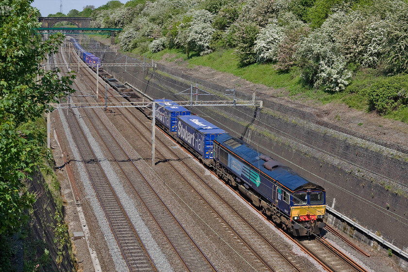 66430, 12.03 DIRFT-Purfleet (4L98), Roade cutting 
 Despite some empty flats near the front of the train, the 4L98 is long and pretty well loaded disappearing off around the curve in Roade cutting. On this lovely spring Sunday the 12.03 Daventry to Purfleet service, dubbed the Tesco Express, is hauled by DRSs' 66430. 
 Keywords: 66430 12.03 DIRFT-Purfleet 4L98 Roade cutting DRS Direct Freight Services Tesco Express