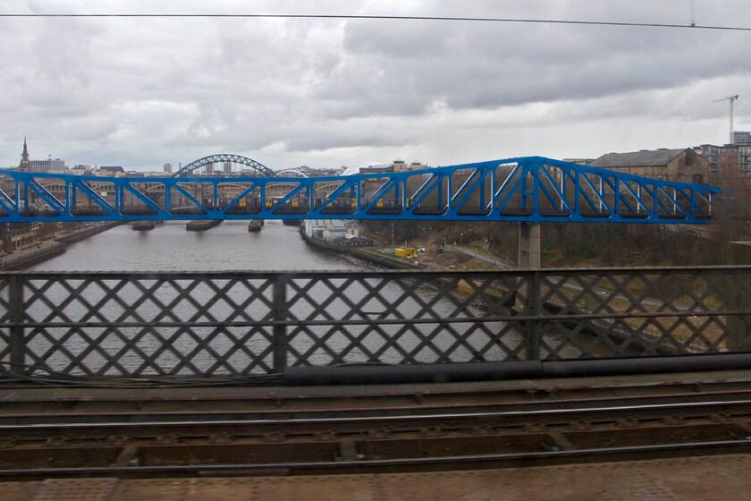 Crossing the Kinge Edward VII bridge from the 09.00 London King's Cross-Edinburgh Waverley, Newcastle 
 I have a thing about taking photographs of or from famous bridges! Seen from the 09.00 King's Cross to Edinburgh service as it crosses Newcastle's 1911 King Edward VII bridge the TYne is seen along with some of the other famous seven bridges that span the river. The blue structure in the foreground is the 1981 Queen Elizabeth II Metro bridge complete with a Class 599 crossing it. 
 Keywords: Crossing the King Edward VII Bridge from the 09.00 London King's Cross-Edinburgh Waverley Newcastle