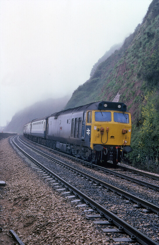 50034, 07.57 Penzance-Liverpool Lime Sreet (1M85), Teignmouth sea wall 
 50034 'Furious' heads along the sea wall through the mist leading the 1M85 07.57 Penzance to Liverpool. The Class 50 would lead the train as far as Birmingham New Street where an AC electric would take over the train to its destination. It would be another year (almost to the day!) until 50034 would head to Doncaster for its much-needed refurbishment emerging back into service again in October 1982. 
 Keywords: 50034 07.57 Penzance-Liverpool Lime Sreet 1M85 Teignmouth sea wall Furious