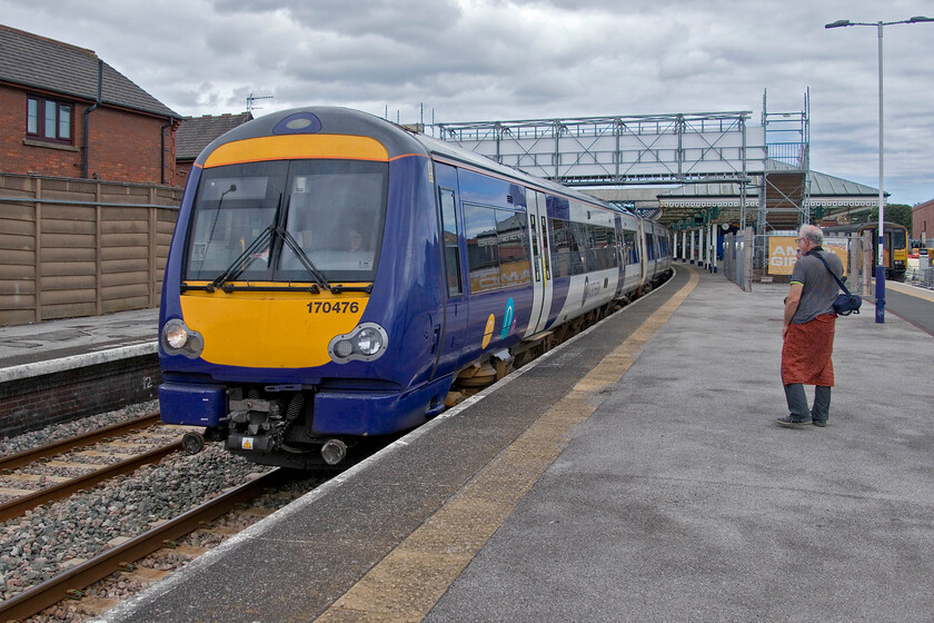 170476, NT 13.02 Scarborough-Hull (1J48, RT), Bridlington station 
 Northern's 170476 leaves Bridlington station working the 13.02 Scarborough to Hull service. Andy and I had travelled on this train from its starting point but it was far from straightforward. With the consultation on the closure of most ticket offices now finished the events of this afternoon's farce are worth sharing.

- Some fifteen minutes before departure Andy and I went to buy a couple of return tickets from Scarborough to Bridlington. We found the queue in the booking hall was several customers deep with one being helped to plan a complicated journey.
- All three ticket machines were out of order.
- We found the guard on the train we intended to travel on sitting in the rear cab and asked to buy a ticket. He said he could not as he did not have a mobile ticket machine. On explaining our problem and asking what we should do he shrugged his shoulders.
- We discussed our predicament with a member of Northern's platform staff, but he also could offer no suggestion as to what to do. What, of course, he could not say was to get on the train and sort the ticket on the journey as this was in breach of Northern's much-publicised policy of passengers not to get on a train without a ticket, quote (from Northern's website), 'ff you board a Northern train without a ticket or Promise to Pay notice at a station where ticket purchasing facilities are available, you may be liable to pay a Penalty Fare. From 23 January 2023, the minimum Penalty Fare is changing from 20 to 100, plus the price of the full single fare applicable for your intended journey. However, if the fine is paid within 21 days, this is reduced to 50 plus the price of the single fare applicable'. All very alarming!
- Totally in breach of Northern's warnings about boarding trains with no ticket, we did so just five minutes before departure. 
- I spent some ten minutes downloading Northern's app to my mobile 'phone well into the start of the journey. 
- By the time the train had reached Seamer I had managed to purchase two return tickets but was unable to load our two-together discount.
- Throughout the journey and on arrival at Bridlington our tickets were not checked with the guard staying in the rear cab throughout the journey (on our leg at least)

Whilst I am a fan of the railways and champion the fine work that they do when situations such as this occur my faith takes a serious dent and I understand why the general public can often be disillusioned with public transport finding it an anathema. 
 Keywords: 170476 13.02 Scarborough-Hull 1J48 Bridlington station Northern