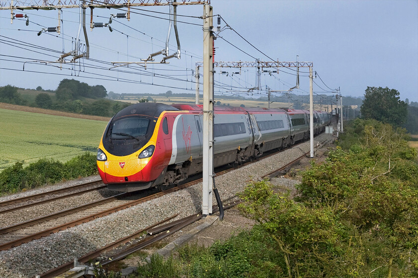 390127, VT 07.05 Wolverhampton-London Euston (1B05), Blisworth SP735539 
 Just a few minutes after the charter led by 86259 'Les Ross/Peter Pan' had headed north in the foggy gloom the sun has got to work and burnt it off 390127 'Virgin Buccaneer' heads south. The Virgin Pendolino is working the 1B05 07.05 Wolverhampton to Euston train and is seen passing near the village of Blisworth just north of Roade in Northamptonshire. 
 Keywords: 390127 VT 07.05 Wolverhampton-London Euston 1B05 Blisworth SP735539 Virgin Pendolino Virgin Buccaneer