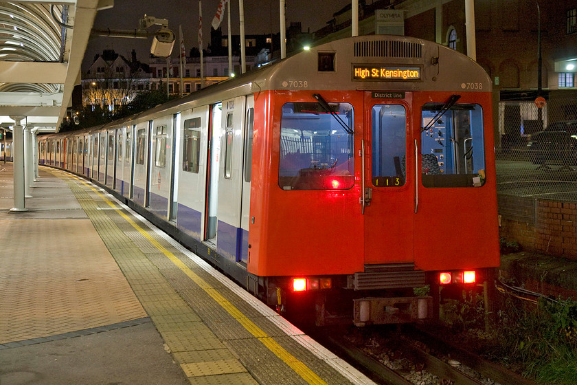 7038, District Line Kensington Olympia-High Street Kensington working, Kensington Olympia station 
 D78 stock set number 7038 waits at Kensington Olympia to work a District Line shuttle service back to High Street Kensington. This stock, dating from 1980, is due for withdrawal to be replaced by more modern units in the coming year or so. 
 Keywords: 7038 District Line Kensington Olympia-High Street Kensington working Kensington Olympia station D78 District Line